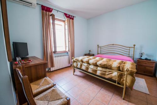 a bedroom with a bed and a desk and a tv at Hotel Fioriti in Matelica