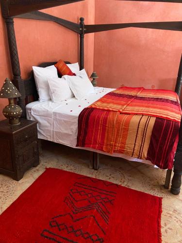 a bedroom with a bed with a red rug at LES JARDINS DE MARRAKECH in Marrakech