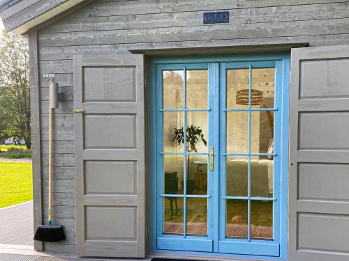 a house with a blue door and a garage at Ragnar Glamp Koknese in Koknese