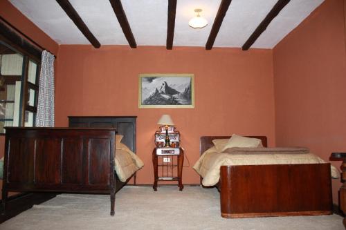 a bedroom with orange walls and a bed and a lamp at Hacienda La Merced Baja in Zuleta