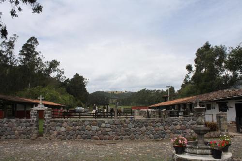 a stone wall in front of a building at Hacienda La Merced Baja in Zuleta