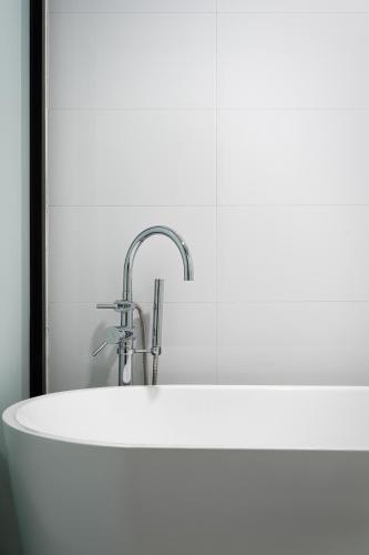 a white sink with a faucet in a bathroom at Unijoy Cityinn OCT Loft Shenzhen有集城市客栈创意园店 in Shenzhen