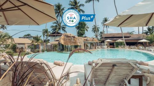 - une piscine avec des chaises et des parasols dans un complexe dans l'établissement Khwan Beach Resort - Luxury Glamping and Pool Villas Samui - Adults Only - SHA Extra Plus, à Mae Nam Beach