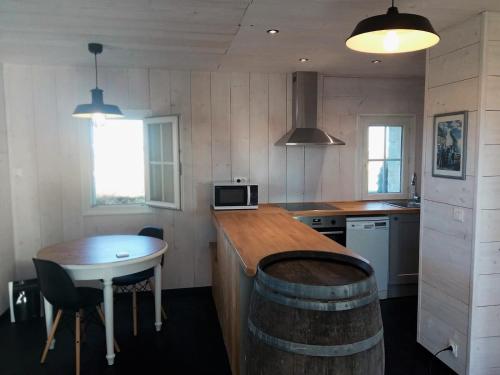 a kitchen with a wooden counter top and a table at La Lanterne du Bout du Monde in Ouessant