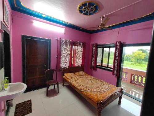 Schlafzimmer mit rosa Wänden, einem Bett und einem Waschbecken in der Unterkunft SHANTI GUEST HOUSE in Srīvardhan