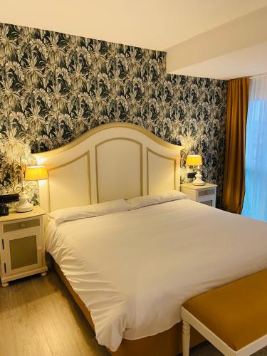 a bedroom with a large white bed with a floral wallpaper at Rey Sancho Palencia in Palencia