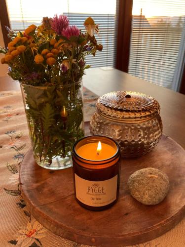 uma vela e um vaso com flores sobre uma mesa em Horské Apartmány Bílý Vlk em Vaclavov u Bruntalu