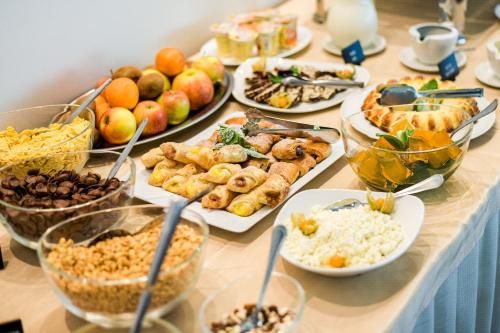 a table with many plates of food on it at Regina in Druskininkai
