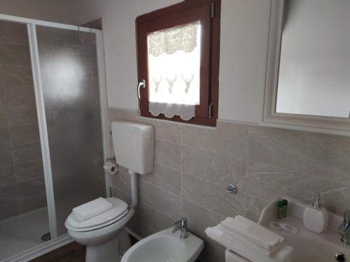 a bathroom with a toilet and a sink and a window at Albergo Diffuso Borgo Retrosi di Amatrice in Amatrice