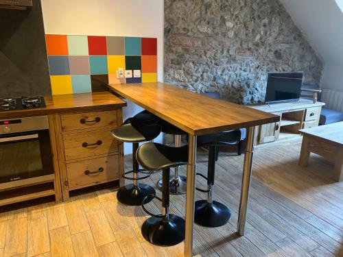una cucina con tavolo in legno, sedie e computer portatile di Annecy Sainte Claire proche Gare-Lac Duplex 4e étage pour 4ou6 personnes climatisation ad Annecy