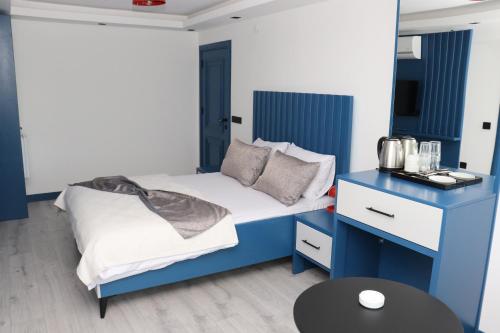 a blue and white bedroom with a bed and a table at Blue Ay Boutique Hotel in Atakum