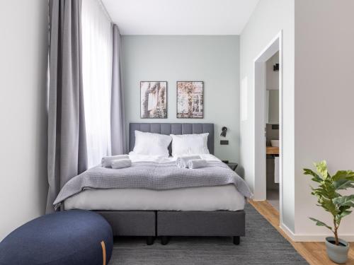 1 dormitorio con 1 cama grande con reposapiés azul en limehome Augsburg Annastraße, en Augsburg