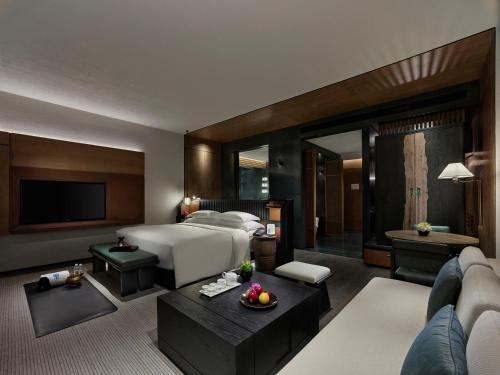 a bedroom with a bed and a living room at Banyan Tree Nanjing Garden Expo in Nanjing