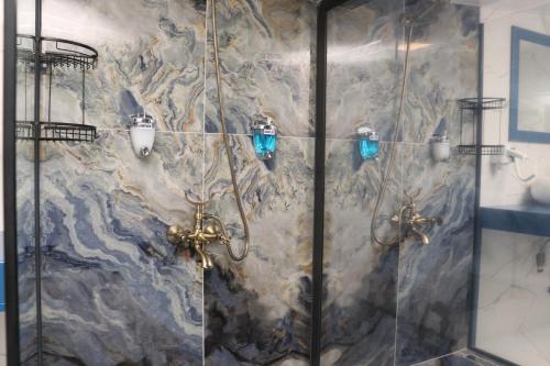 a shower in a bathroom with a stone wall at Blue Ay Boutique Hotel in Atakum