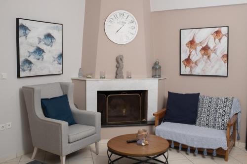 a living room with two chairs and a clock on the wall at Punda 4 Seasons in Diakopto