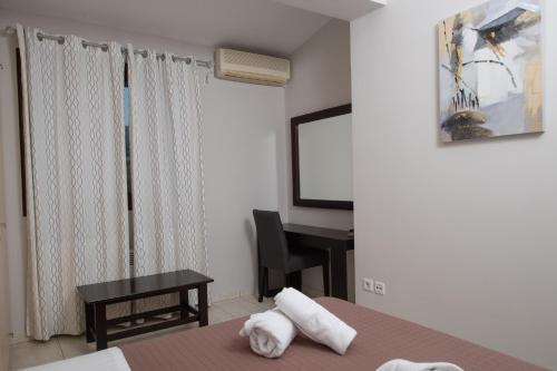 a bedroom with a bed and a desk and a television at Punda 4 Seasons in Diakopto