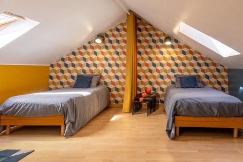 two beds in a room with yellow walls at Le Félix Grat - LAVALOC in Laval