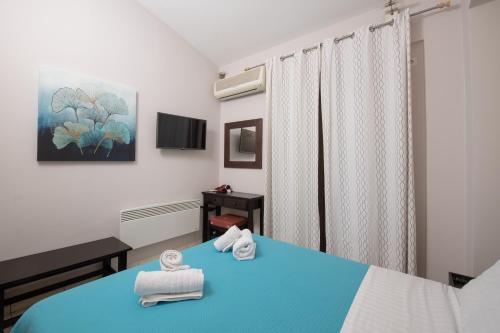 a bedroom with a blue bed with towels on it at Punda 4 Seasons in Diakopto