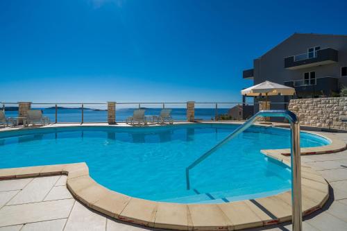 una gran piscina con el océano en el fondo en Apartments Marnic- Blue Chill en Mlini