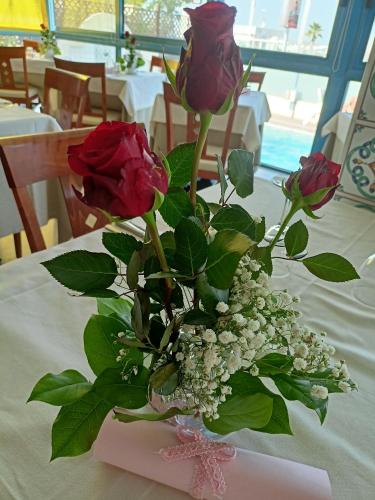 a bouquet of roses in a vase on a table at Hotel Ascot Riccione in Riccione