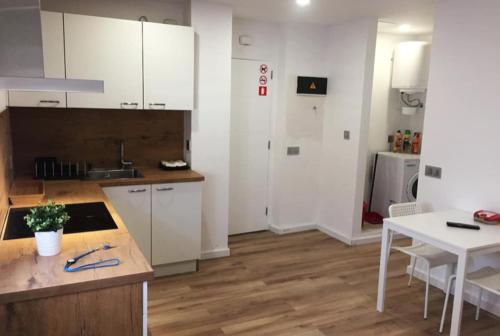 a kitchen with white cabinets and a table and a counter at MAMI / Apto 6 in San Sebastián de la Gomera