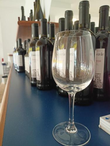 a wine glass sitting on top of a table with wine bottles at Hotel Ascot Riccione in Riccione