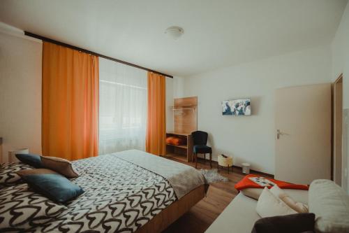 a bedroom with a bed and a couch at Apartman Lovrić Đakovo in Đakovo
