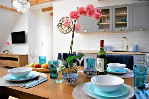 een eettafel met een fles wijn en bloemen bij Apartamenty Royal Maris 4 - najlepsza lokalizacja w Ustce, blisko plaży i portu, bezpłatny parking, ścicsłe centrum in Ustka