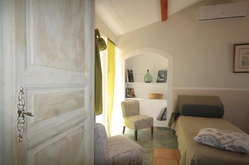 a room with a door and a bed and a chair at Logis Hôtel Restaurant Le Domaine de l'Eau Vive in Largentière