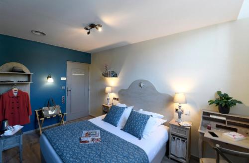 a bedroom with a bed with blue walls and a desk at The Originals Boutique, Hôtel du Parc, Cavaillon in Cavaillon