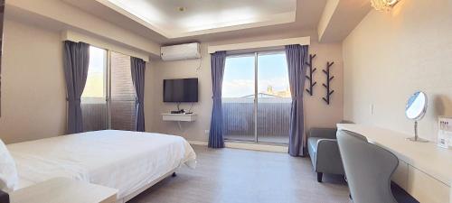 a hotel room with a bed and a large window at SUN 9 Inn in Hengchun South Gate
