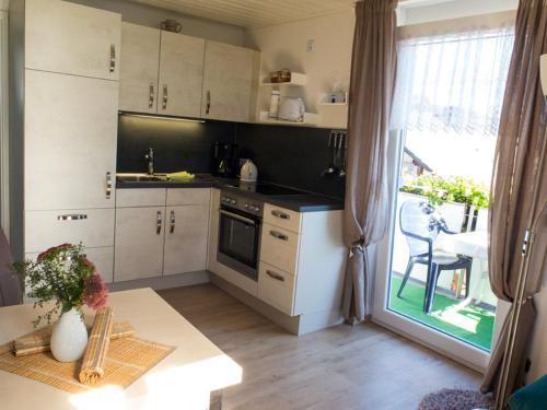 a kitchen with white cabinets and a table and a window at Ferienwohnungen Meyer in Beilngries