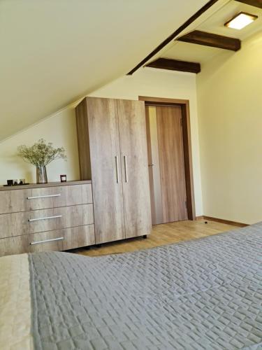 - une chambre avec un grand lit et des placards en bois dans l'établissement Zelena Saduba, à Nevitskoye