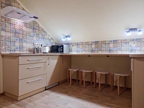 a kitchen with a counter with stools in it at Zelena Saduba in Nevitskoye