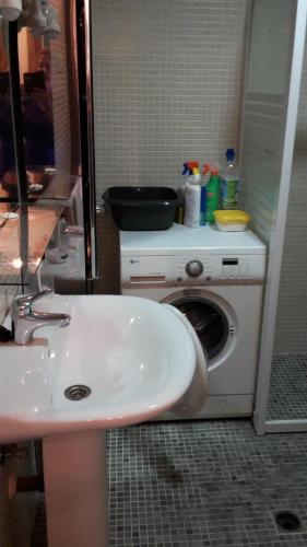 een badkamer met een wastafel en een wasmachine bij Bravo 24 in Fuengirola