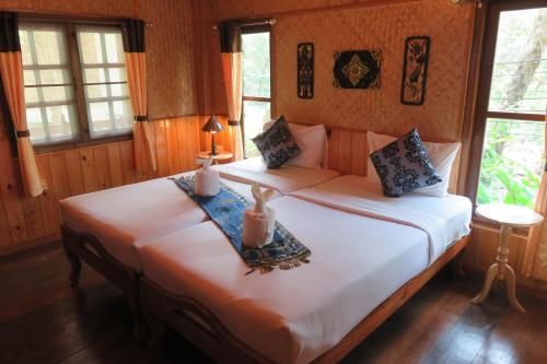 a bedroom with a large bed with two candles on it at Macura Resort in Ko Chang