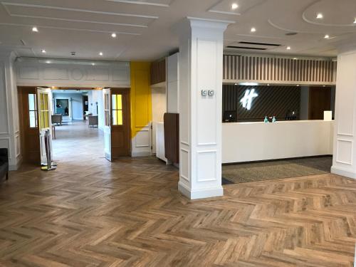 an office lobby with a wooden floor and columns at Holiday Inn Doncaster A1- M Jct 36 by IHG in Doncaster