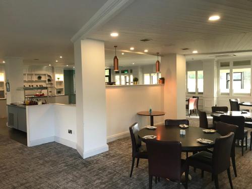 a dining room with tables and chairs and a kitchen at Holiday Inn Doncaster A1- M Jct 36 by IHG in Doncaster
