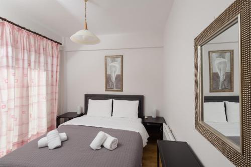 a bedroom with a bed with white pillows and a mirror at Punda 4 Seasons in Diakopto