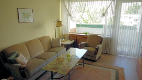 ハノーファーにあるComfortable apartment for 2 Personsのリビングルーム(ソファ、テーブル付)、窓が備わります。
