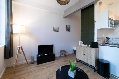 un salon avec une table et une télévision dans l'établissement LE COLOMBETA - HYPERCENTRE - GARE - NETFLIX, à Toulouse