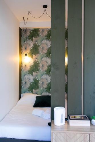 - une chambre avec un lit et un mur orné de palmiers dans l'établissement LE COLOMBETA - HYPERCENTRE - GARE - NETFLIX, à Toulouse