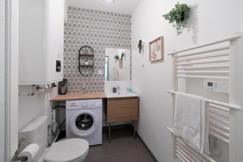 une salle de bain avec une machine à laver et un lavabo dans l'établissement LE COLOMBETA - HYPERCENTRE - GARE - NETFLIX, à Toulouse