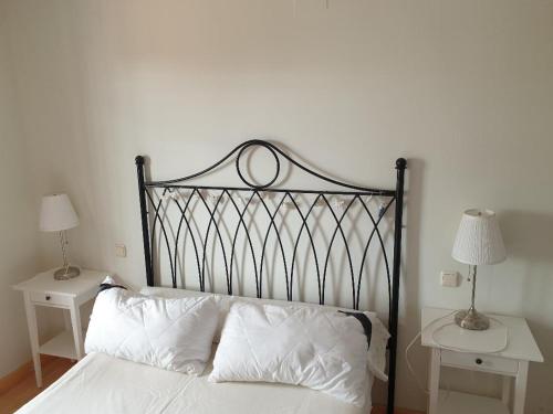 フエンヒロラにあるBravo 24のベッド1台(白い枕付)、テーブル2台(ランプ付)