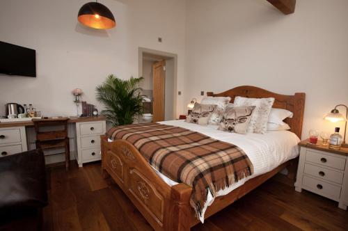 um quarto com uma grande cama de madeira com almofadas em The Pig Inn em Snaith