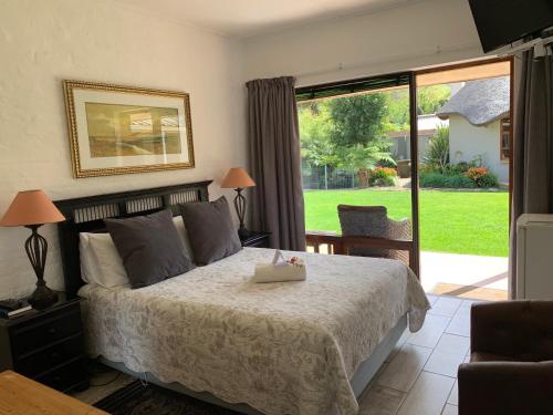 Un dormitorio con una cama y una puerta corrediza de vidrio. en Mountain Dew Guest House, en George