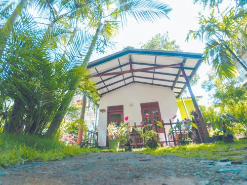 a small white house with a blue roof at Rest Full Homestay in Ella