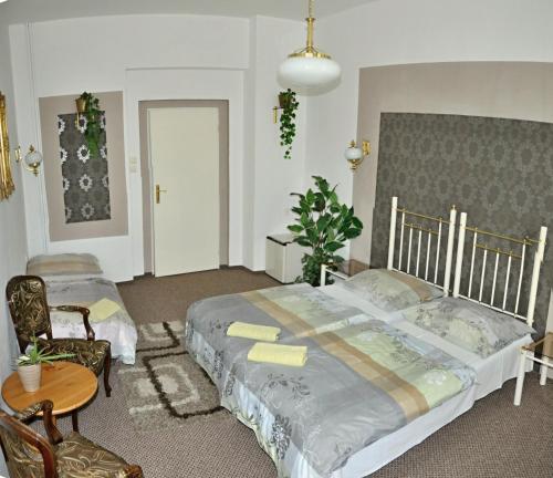 テプリツェにあるHotel Green Houseのベッドルーム1室(大型ベッド1台、テーブル、椅子付)