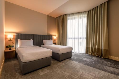 a hotel room with two beds and a window at Maestral in Lviv