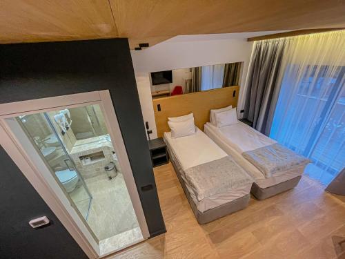 a hotel room with two beds and a shower at Ursuletul Predeal in Predeal